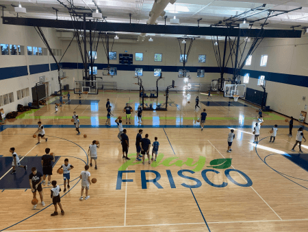 Kids playing basketball inside a gymnasium 