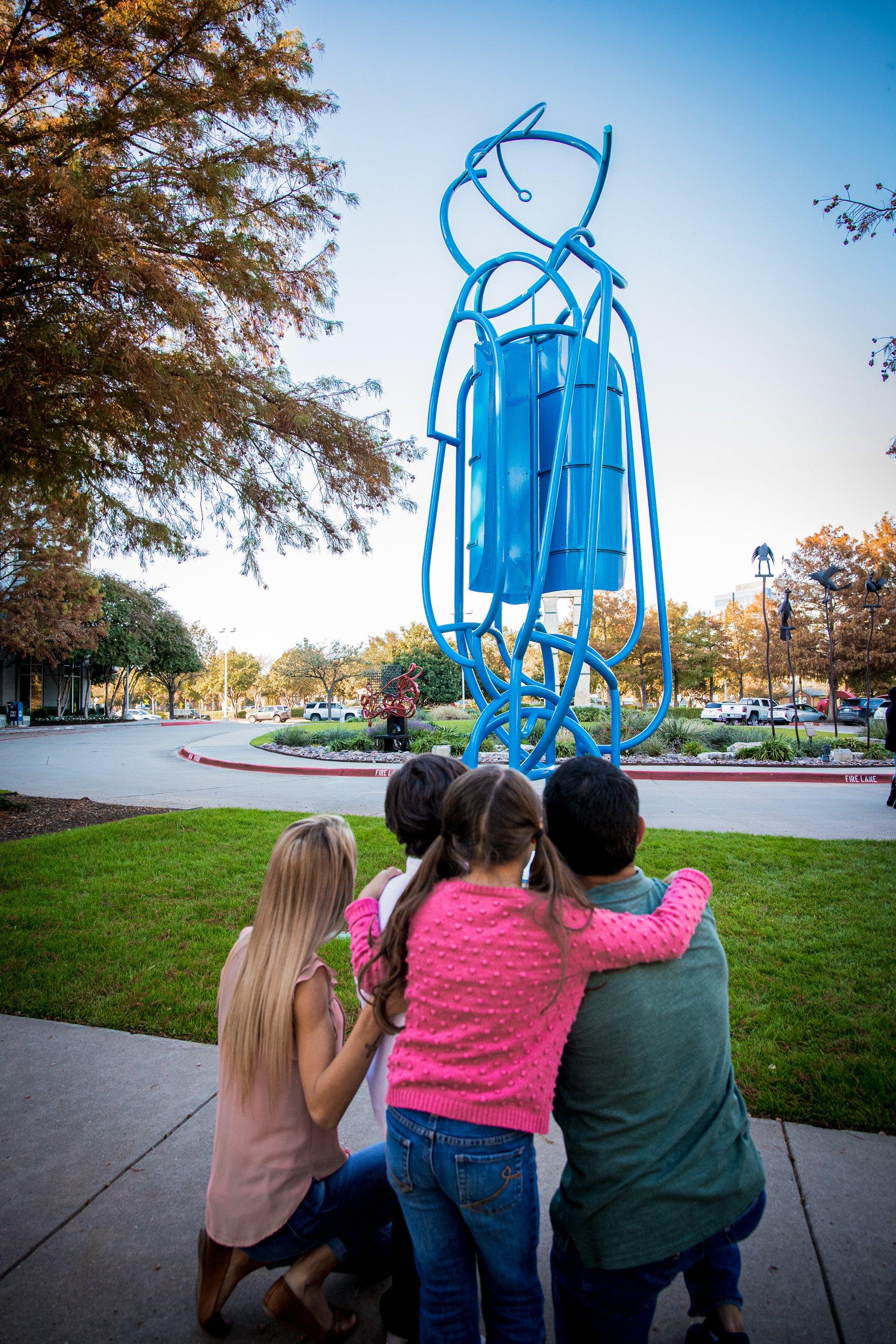 A family taking in an abstract sculpture