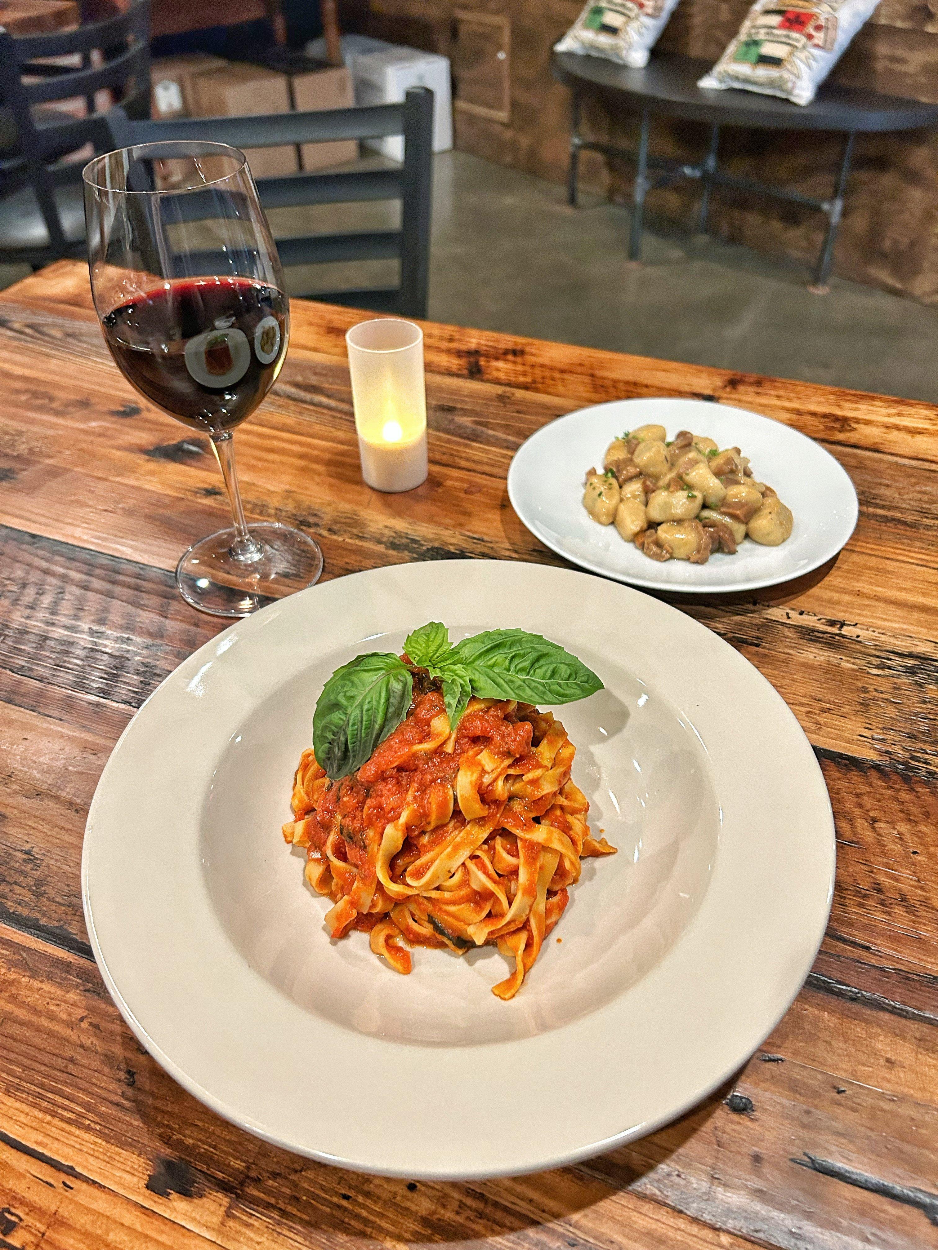 An assortment of pasta and a glass of red wine at Baonecci