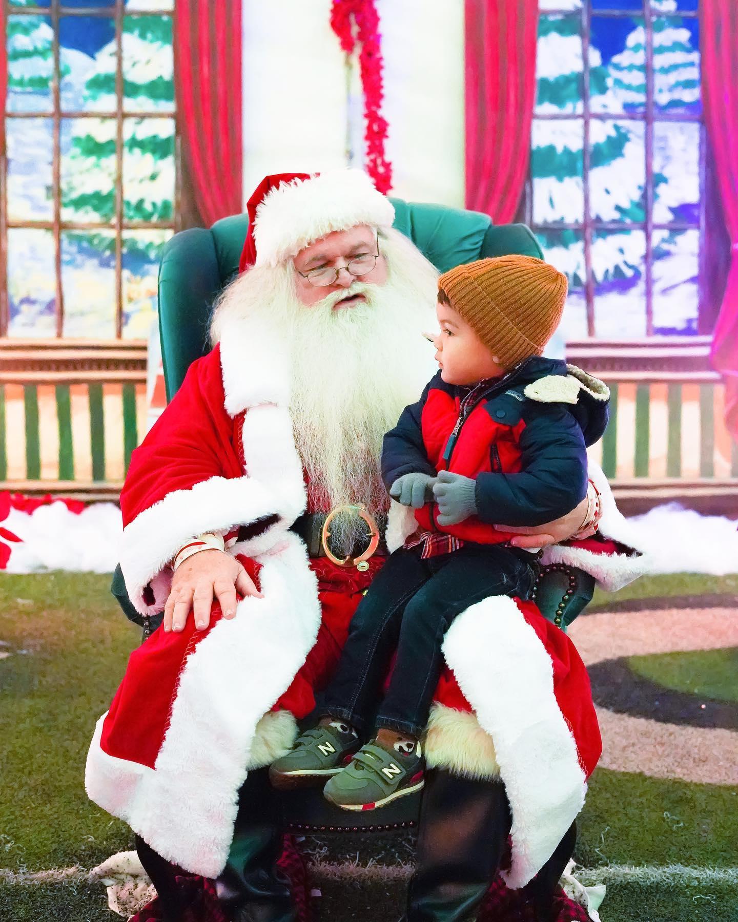 A little boy sitting on santa's lap