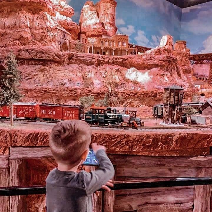 A little biy looking at a train set