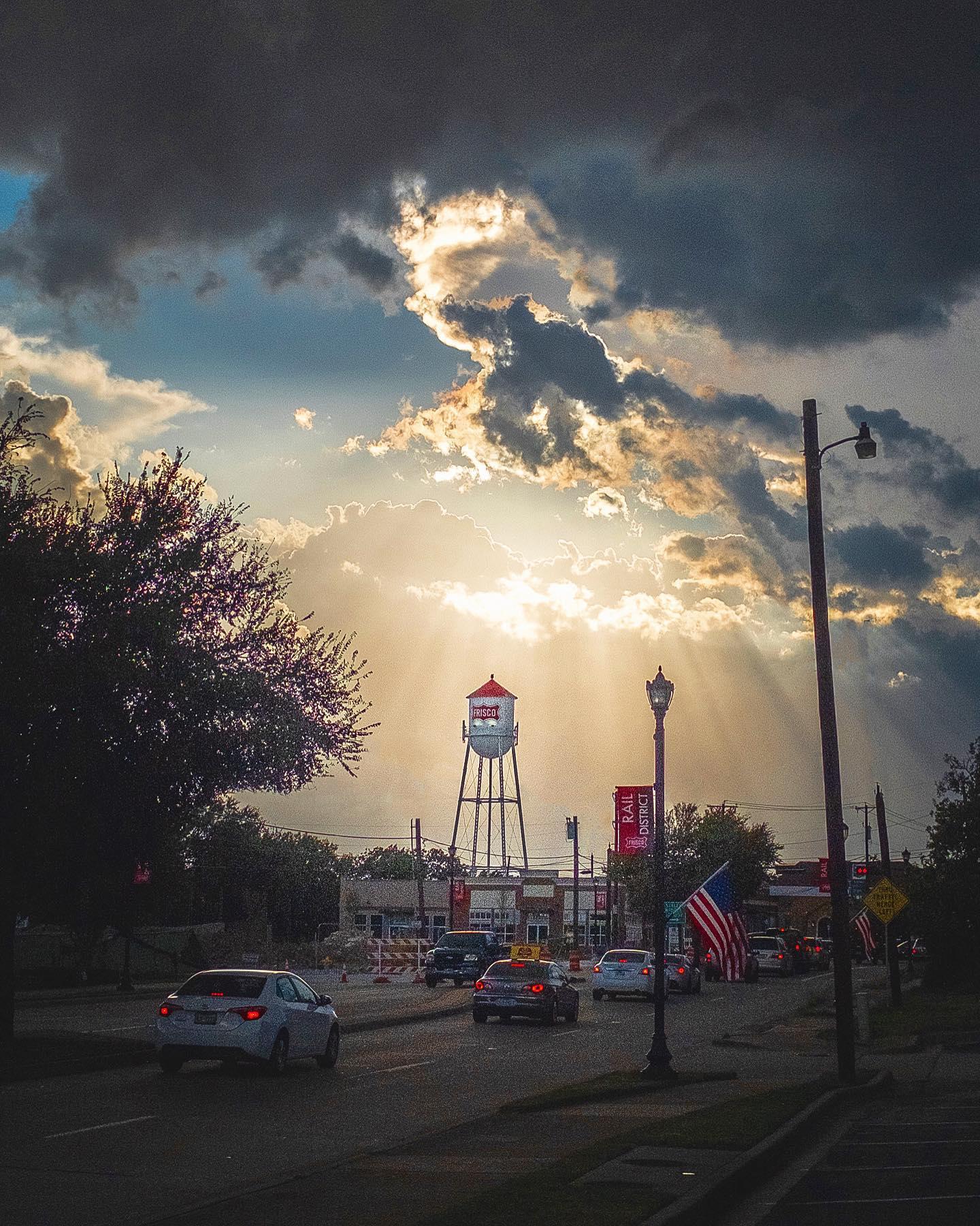 Rail District street with cars, a water tower and the sun shining on the street