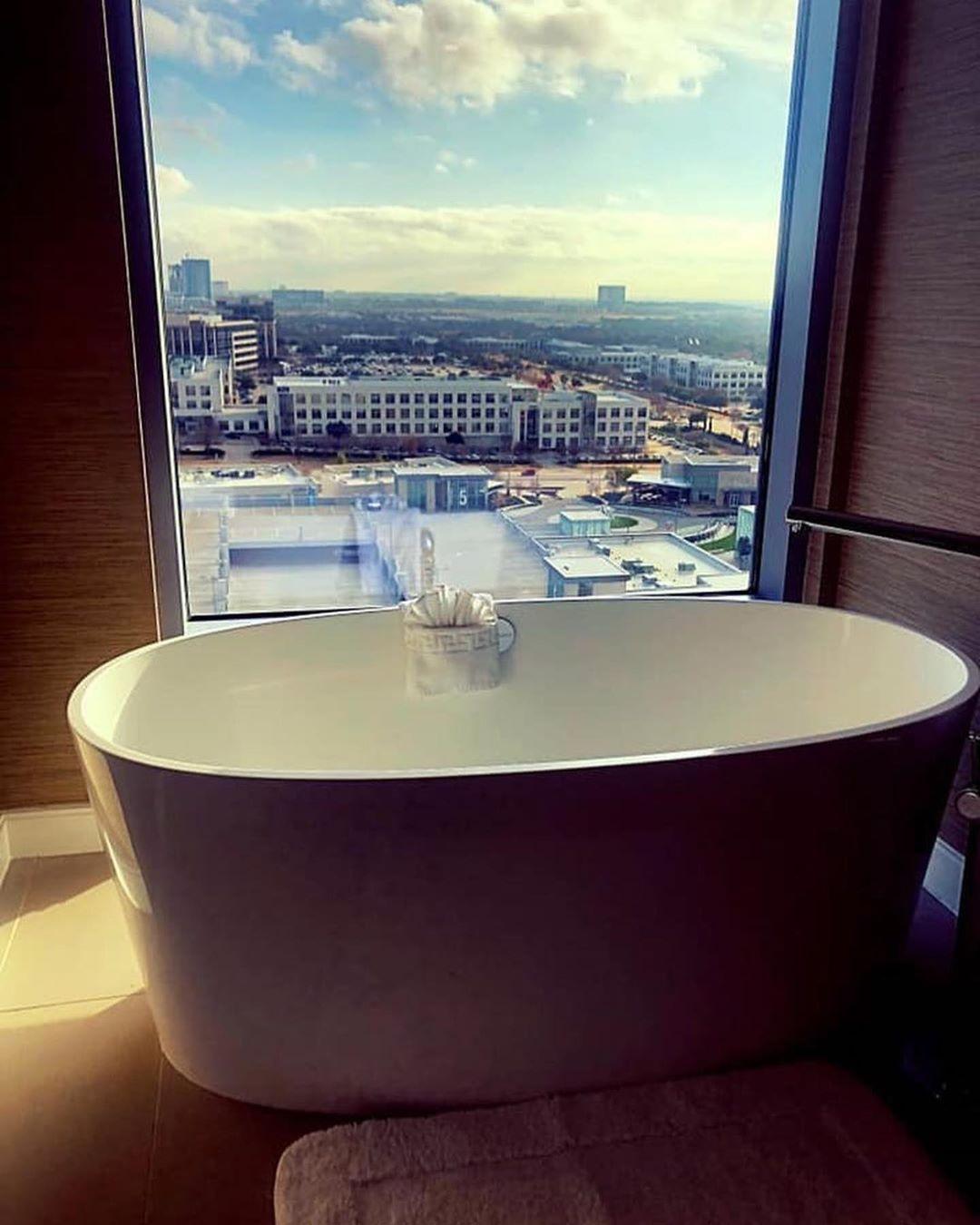 an empty bathtub in front of a window