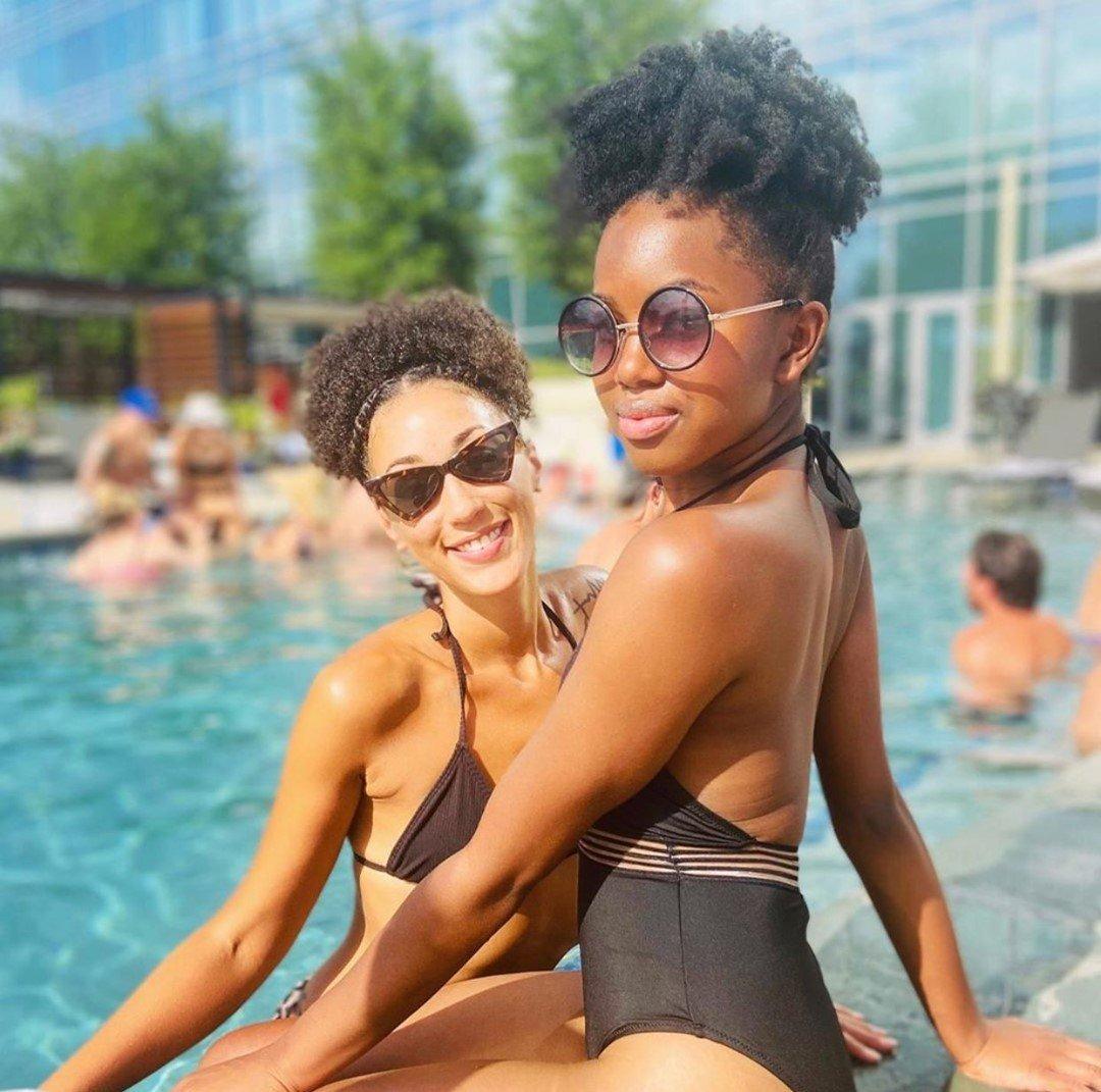 two women posing by the pool
