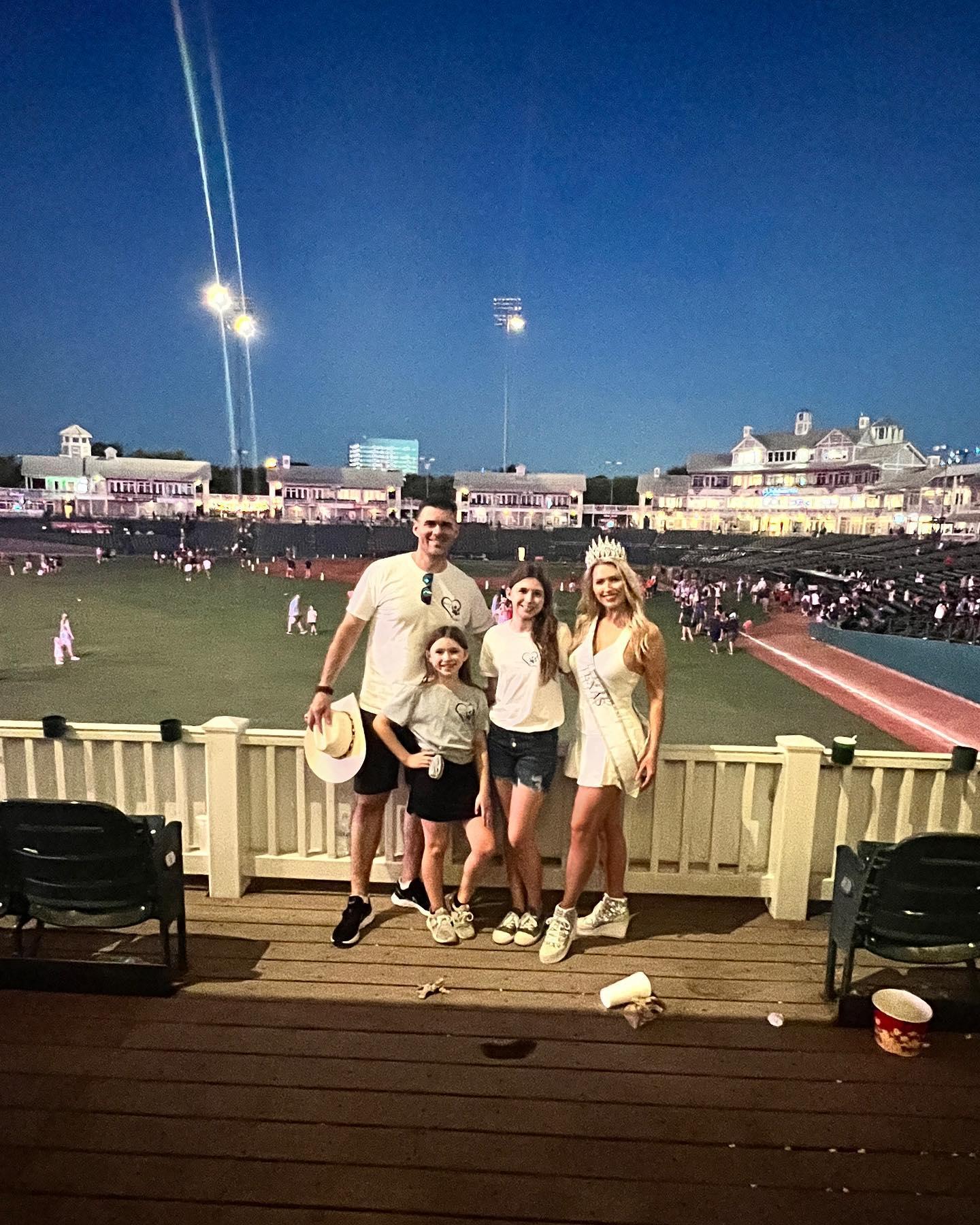 A family posing for a photo at a RoughRiders game